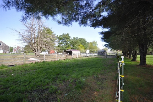 view of yard featuring fence and an outbuilding