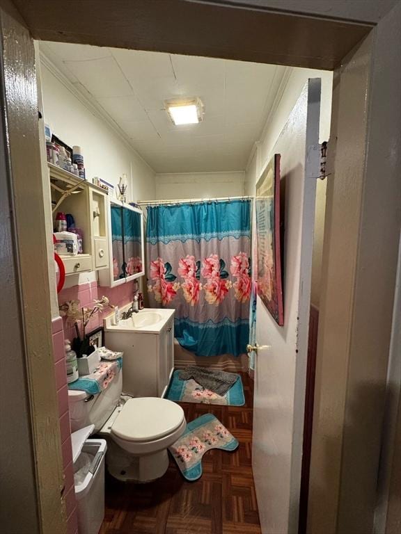bathroom featuring toilet, a sink, ornamental molding, and a shower with shower curtain