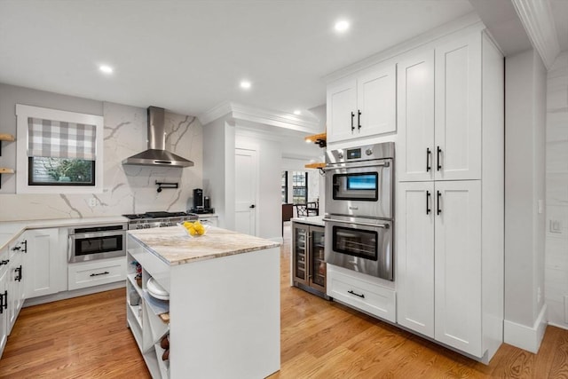 kitchen featuring beverage cooler, open shelves, light wood-style floors, appliances with stainless steel finishes, and wall chimney exhaust hood