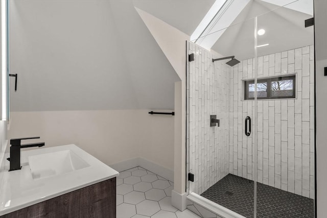 full bath with lofted ceiling, a stall shower, tile patterned flooring, baseboards, and vanity