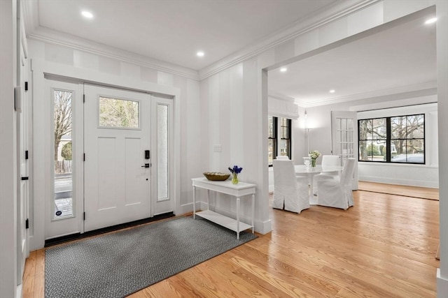 foyer entrance with light wood-style flooring, recessed lighting, and ornamental molding