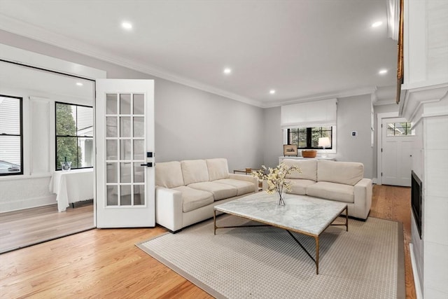 living room featuring recessed lighting, baseboards, light wood-style floors, and ornamental molding