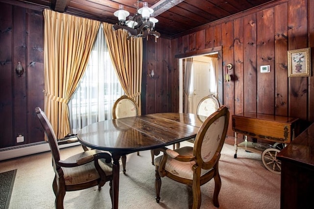 carpeted dining room with a baseboard radiator, wooden walls, a chandelier, and wooden ceiling