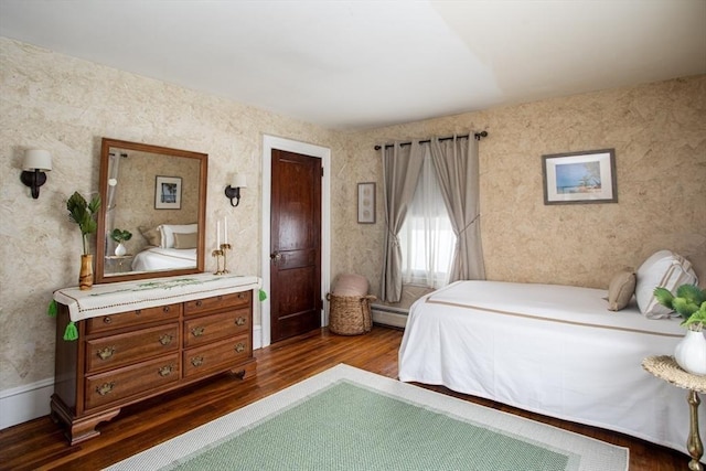 bedroom with hardwood / wood-style floors and baseboard heating