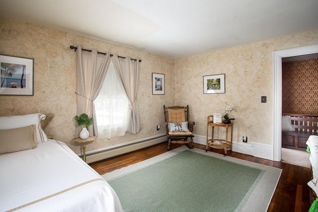 bedroom with a baseboard heating unit and wood-type flooring