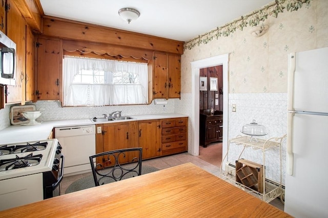 kitchen featuring sink, light tile patterned floors, and white appliances