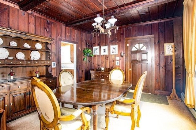 dining area featuring beam ceiling, wooden ceiling, a chandelier, and wood walls