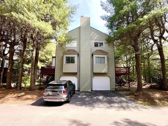 194 Captain Eames Cir Unit 194, Ashland, MA 01721 - view of front facade featuring driveway, an attached garage, a wooden deck, and a chimney