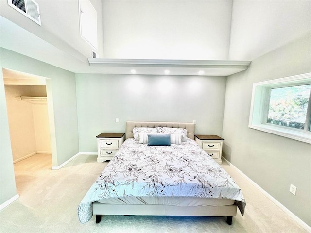 194 Captain Eames Cir Unit 194, Ashland, MA 01721 - bedroom with light colored carpet, a towering ceiling, baseboards, and a walk in closet