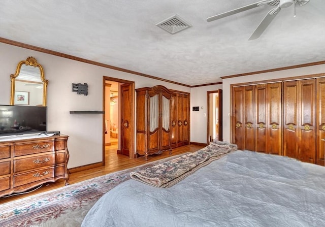 bedroom featuring light hardwood / wood-style flooring, ceiling fan, ornamental molding, a textured ceiling, and a closet