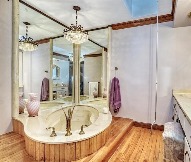 bathroom featuring a chandelier, vanity, ornamental molding, and hardwood / wood-style flooring