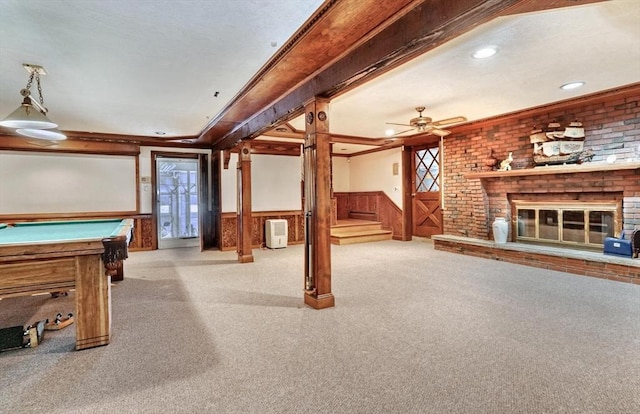 recreation room with light colored carpet, ceiling fan, crown molding, a fireplace, and pool table