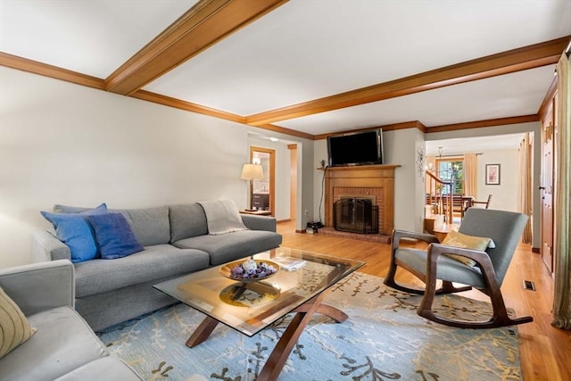 1857 Great Pond Rd, North Andover, MA 01845 - living area with light wood-style flooring, beam ceiling, a brick fireplace, and ornamental molding