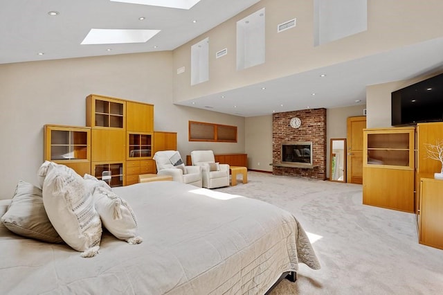 bedroom with a brick fireplace, light colored carpet, high vaulted ceiling, and a skylight