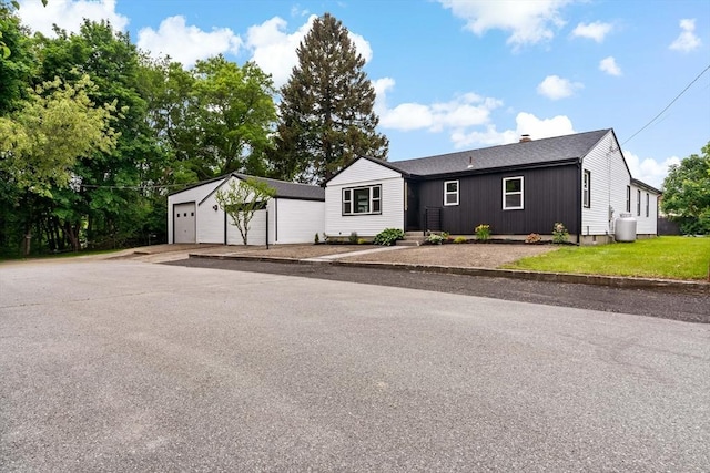 23 Donna St, Westport, MA 02790 - view of front of home featuring a garage, an outdoor structure, a chimney, and roof with shingles