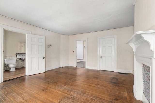 unfurnished living room featuring hardwood / wood-style floors and baseboards