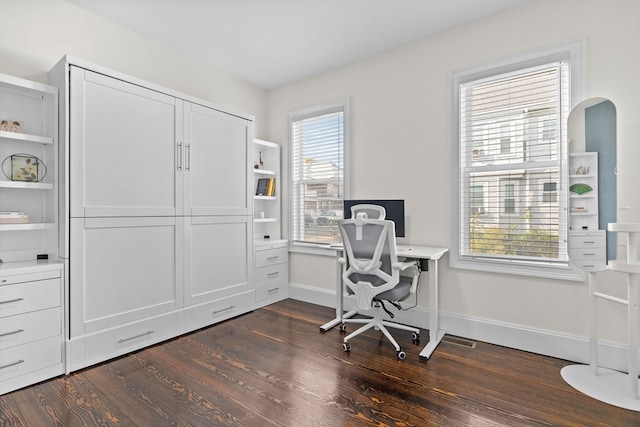 office with a healthy amount of sunlight and dark hardwood / wood-style floors