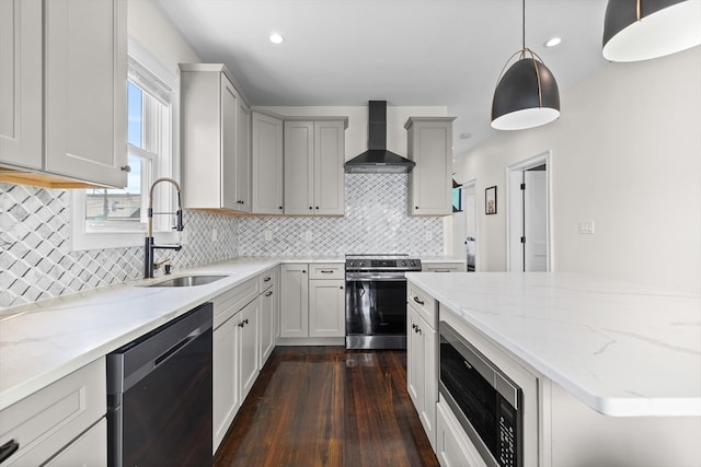 kitchen featuring sink, hanging light fixtures, wall chimney exhaust hood, appliances with stainless steel finishes, and dark hardwood / wood-style flooring