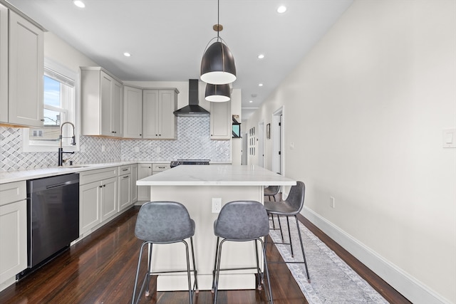 kitchen with dark hardwood / wood-style flooring, a kitchen island, stainless steel appliances, and wall chimney range hood