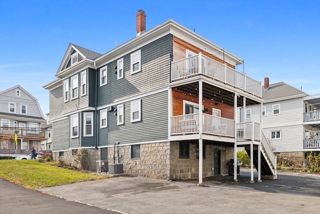 back of property with a balcony and central air condition unit