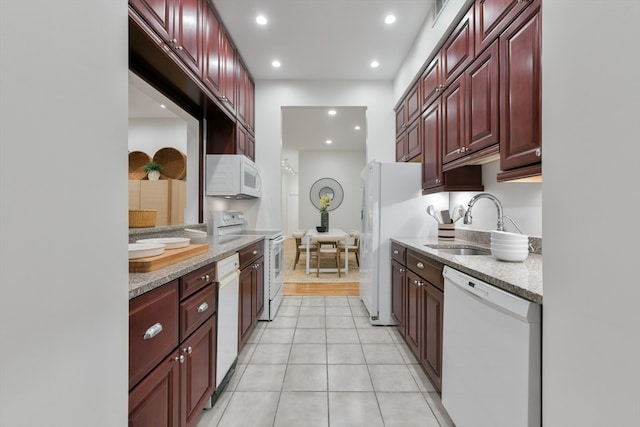 kitchen featuring light tile patterned flooring, white appliances, and sink