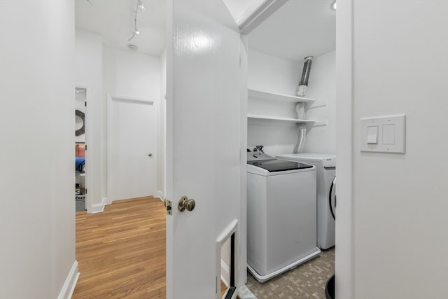 clothes washing area featuring light hardwood / wood-style floors and washing machine and clothes dryer