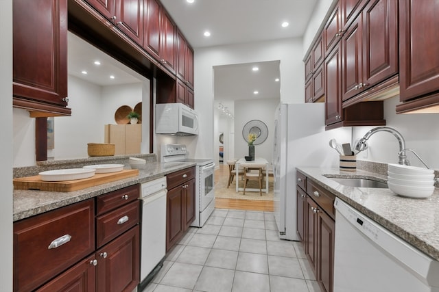 kitchen with light hardwood / wood-style flooring, white appliances, and sink