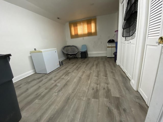 interior space with baseboards and wood finished floors