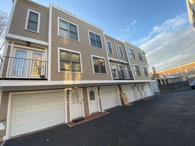 multi unit property featuring an attached garage and driveway