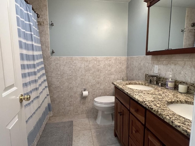239 Prospect St Unit 241-3, Cambridge, MA 02139 - bathroom featuring double vanity, toilet, tile walls, tile patterned flooring, and wainscoting