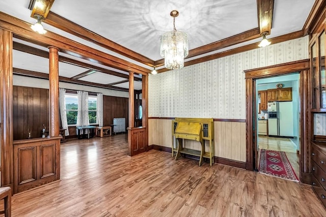 dining room featuring radiator, a chandelier, wainscoting, and wood finished floors