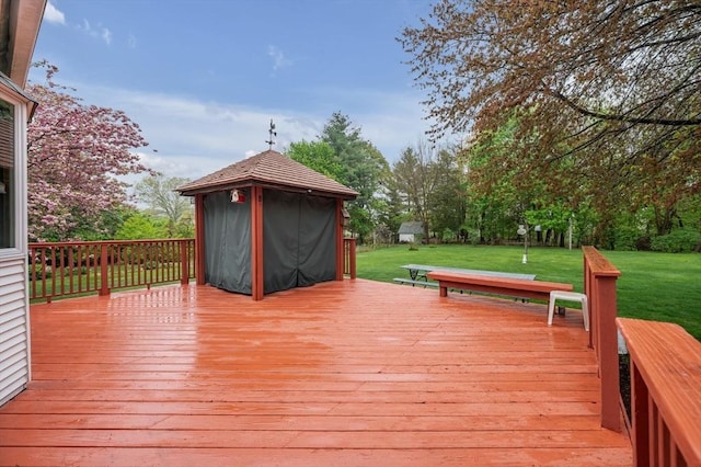 wooden terrace featuring a yard and a gazebo