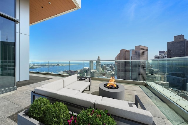 balcony featuring a water view and an outdoor living space with a fire pit