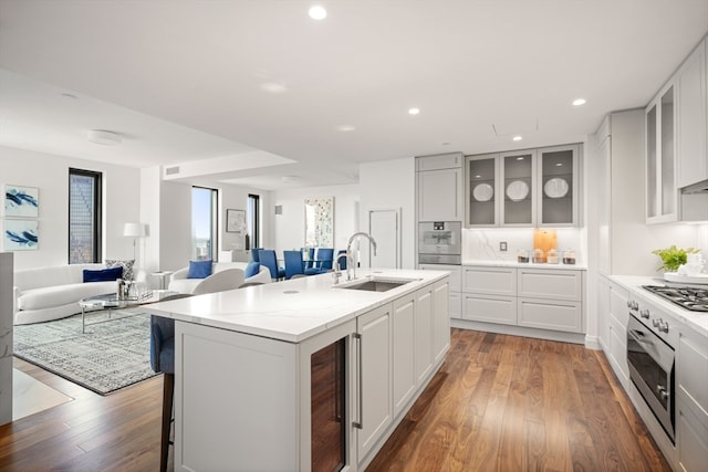 kitchen with dark hardwood / wood-style floors, sink, white cabinets, stainless steel oven, and wall oven