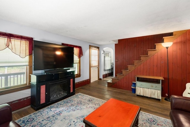 24 Webber Rd, Brookfield, MA 01506 - living area featuring arched walkways, stairway, wood walls, wood finished floors, and baseboards