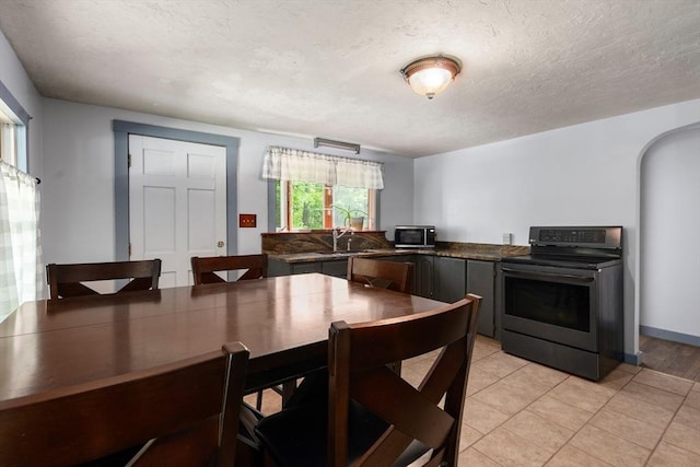24 Webber Rd, Brookfield, MA 01506 - dining room with light tile patterned floors, arched walkways, and a textured ceiling