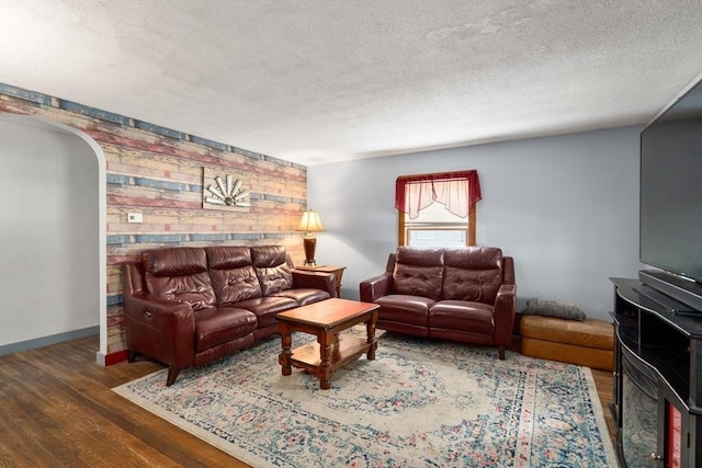 24 Webber Rd, Brookfield, MA 01506 - living room featuring wood finished floors, a textured ceiling, arched walkways, and baseboards