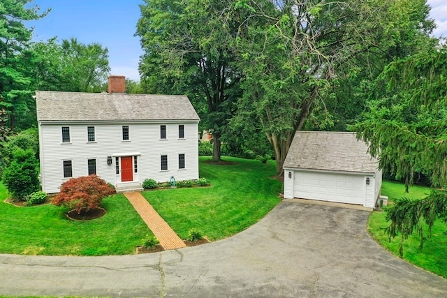 colonial inspired home with a front yard and a garage