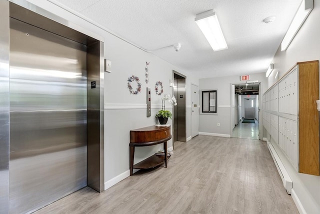 51 Melrose St Unit 5A, Melrose, MA 02176 - hall featuring elevator, light wood-style floors, and a baseboard radiator