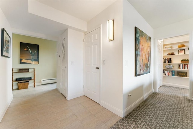 corridor with a baseboard heating unit and baseboards
