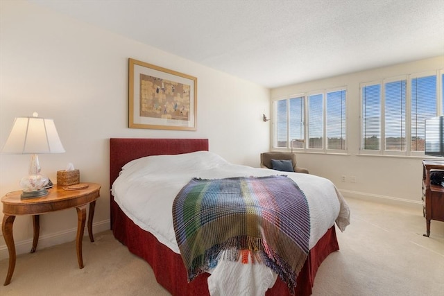 bedroom featuring light colored carpet and baseboards