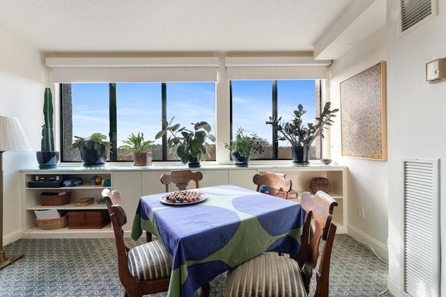carpeted dining room with plenty of natural light and baseboards