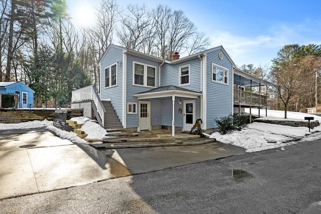 view of front of house with a chimney and stairway