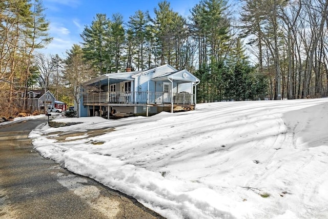 view of front of property featuring a chimney and a wooden deck