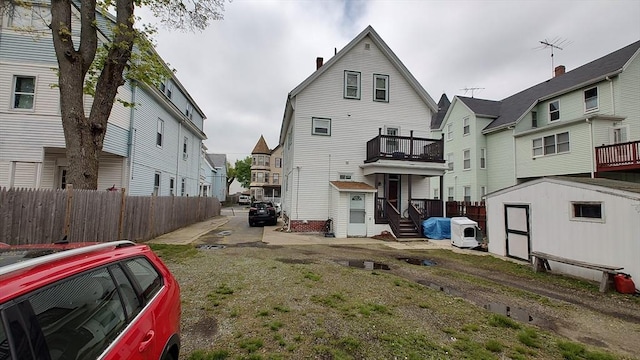 rear view of property with an outbuilding, fence, a shed, ac unit, and a residential view
