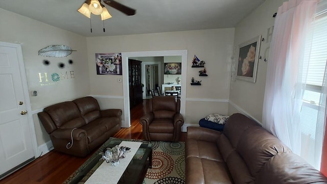 living area with ceiling fan, baseboards, and wood finished floors