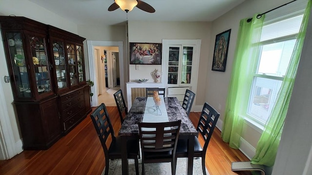 dining room featuring baseboards, ceiling fan, and wood finished floors