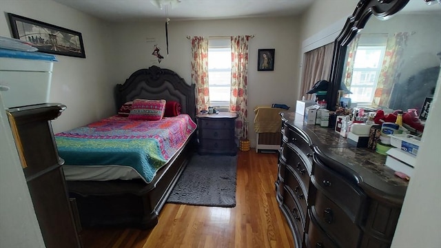 bedroom featuring multiple windows and wood finished floors