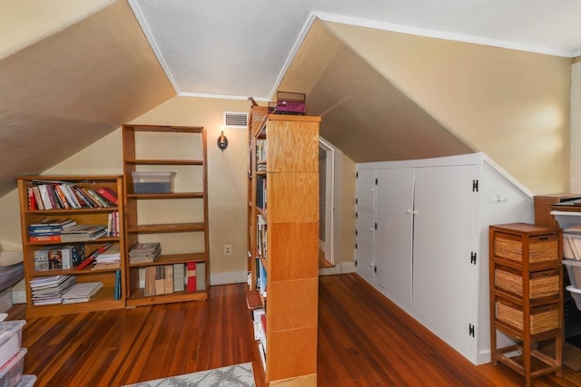 interior space featuring ornamental molding, vaulted ceiling, and dark hardwood / wood-style flooring