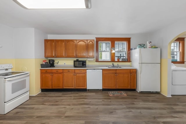 kitchen with plenty of natural light, washer / clothes dryer, hardwood / wood-style flooring, and white appliances